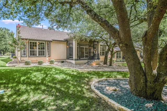 back of property with a sunroom and a yard