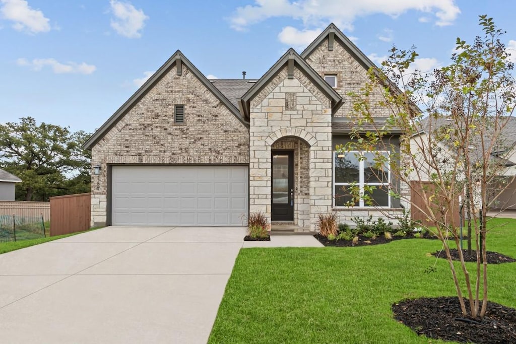 view of front of house featuring a garage and a front lawn