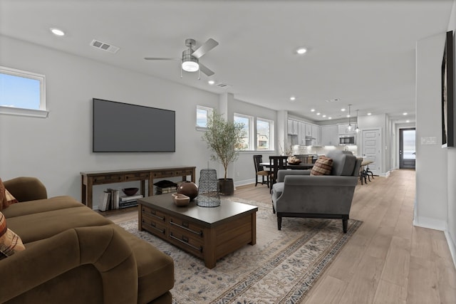 living room featuring light wood-type flooring and ceiling fan