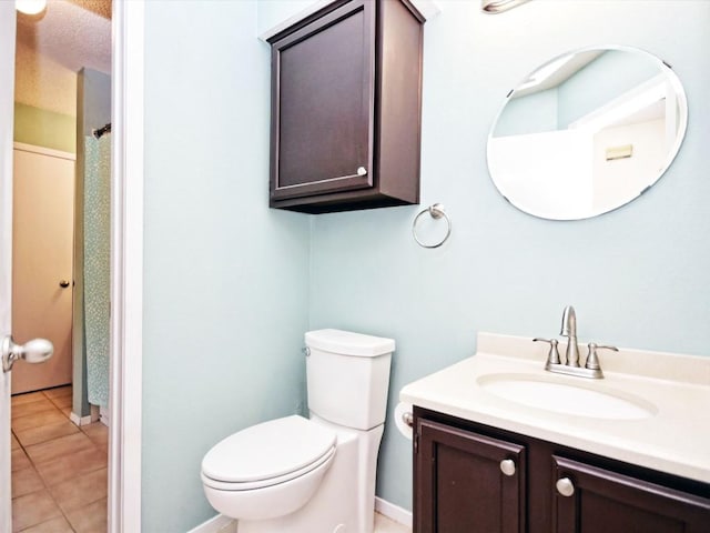 bathroom featuring tile patterned flooring, vanity, and toilet