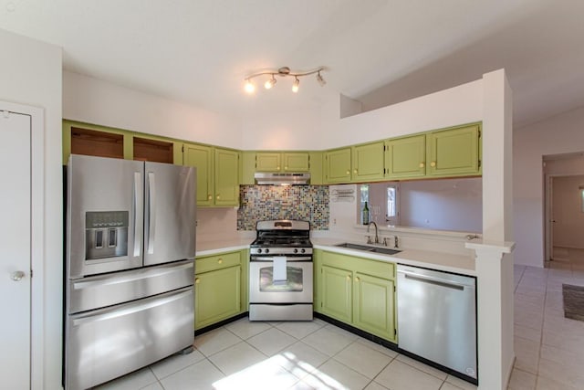 kitchen featuring lofted ceiling, sink, decorative backsplash, green cabinetry, and stainless steel appliances