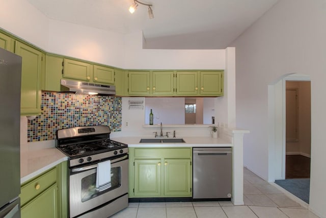 kitchen with appliances with stainless steel finishes, sink, light tile patterned floors, and green cabinetry