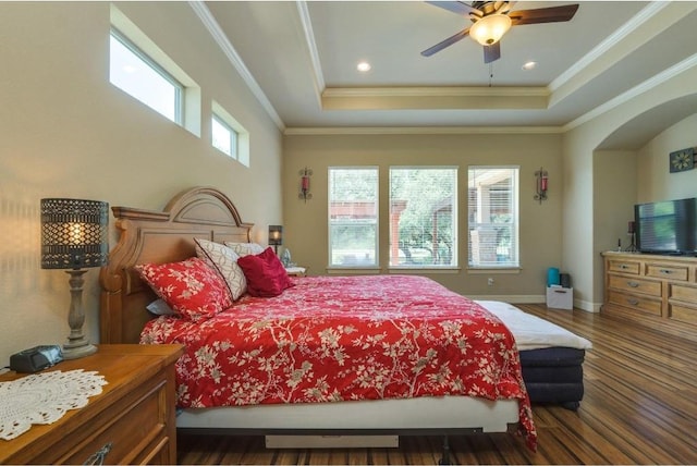 bedroom with ceiling fan, dark hardwood / wood-style floors, a raised ceiling, and crown molding