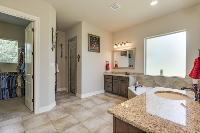 bathroom featuring tile patterned flooring, shower with separate bathtub, and vanity