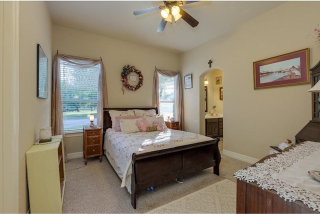 carpeted bedroom featuring ceiling fan and ensuite bathroom