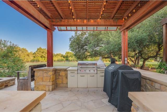 view of patio with an outdoor kitchen, area for grilling, and a pergola