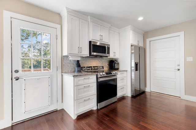 kitchen with light stone countertops, white cabinetry, appliances with stainless steel finishes, and decorative backsplash