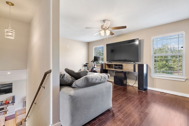 living room with dark wood-type flooring and ceiling fan