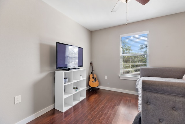 living area featuring dark wood-type flooring and ceiling fan