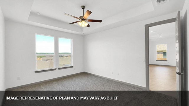 unfurnished room featuring a raised ceiling and ceiling fan