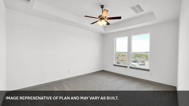 carpeted empty room featuring a raised ceiling and ceiling fan