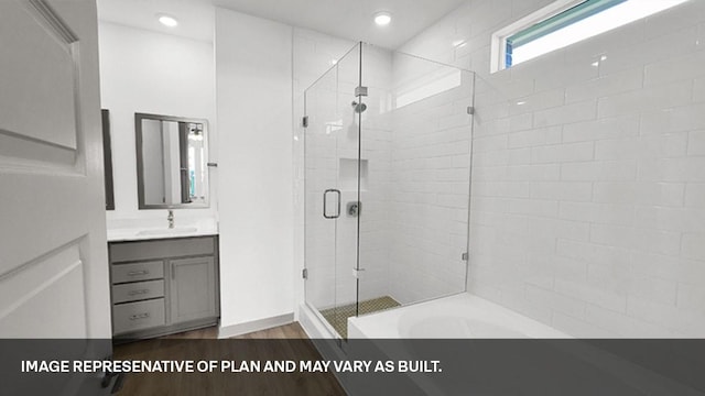 bathroom featuring plus walk in shower, hardwood / wood-style flooring, and vanity