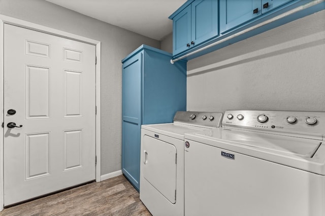 laundry area with cabinets, wood-type flooring, and independent washer and dryer