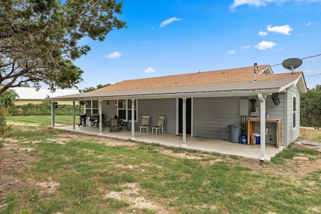 rear view of property featuring a patio and a lawn