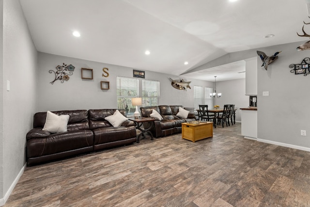 living room featuring hardwood / wood-style flooring, a notable chandelier, and lofted ceiling