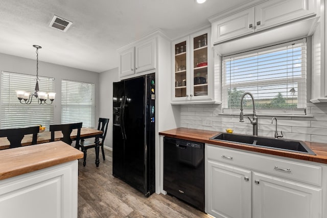 kitchen with black appliances, sink, hanging light fixtures, backsplash, and white cabinetry