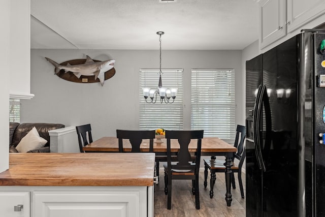 dining room with light wood-type flooring and a chandelier