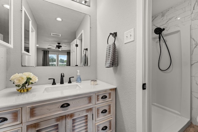 bathroom featuring vanity, a tile shower, and ceiling fan