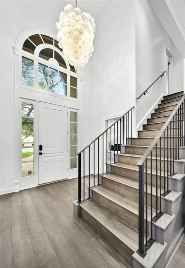 foyer with a chandelier, a high ceiling, and hardwood / wood-style floors