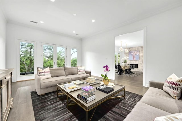 living room with dark hardwood / wood-style flooring, an inviting chandelier, and ornamental molding