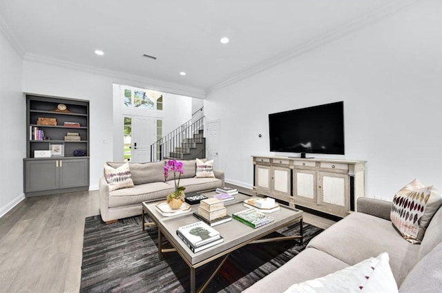 living room featuring built in shelves, dark wood-type flooring, and ornamental molding