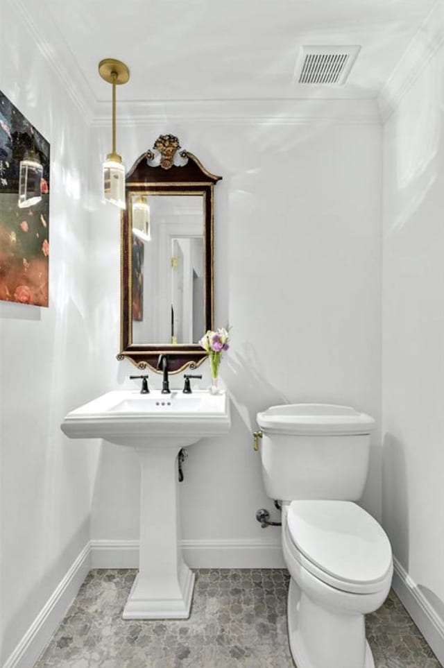 bathroom with toilet and crown molding