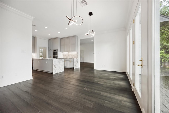 kitchen with decorative light fixtures, a wealth of natural light, and ornamental molding