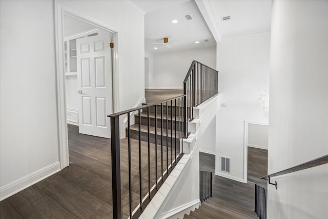 staircase with hardwood / wood-style flooring and crown molding