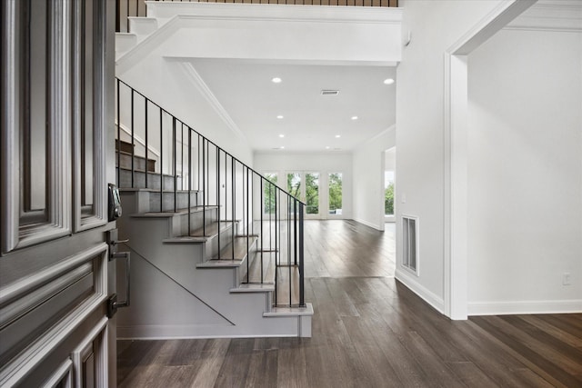 stairs with crown molding and hardwood / wood-style floors