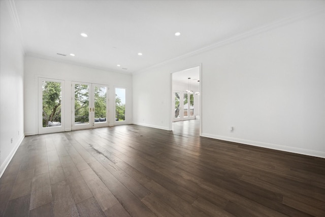 empty room with dark hardwood / wood-style floors, ornamental molding, and french doors