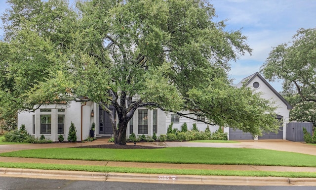 view of property hidden behind natural elements with a front yard