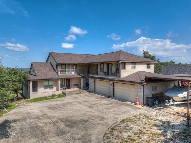 view of front facade featuring a garage, roof with shingles, driveway, and a balcony