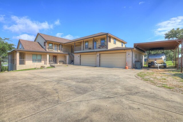 view of front of home with a garage, concrete driveway, brick siding, and a carport