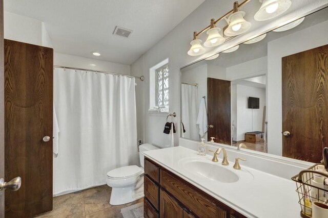 bathroom featuring visible vents, vanity, and toilet