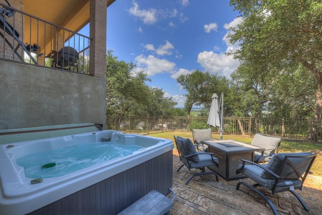 view of patio featuring fence and a hot tub