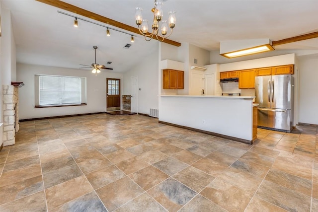 kitchen featuring pendant lighting, stainless steel refrigerator, track lighting, ceiling fan with notable chandelier, and vaulted ceiling