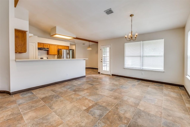 unfurnished living room featuring a chandelier