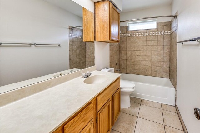 full bathroom featuring vanity, tiled shower / bath combo, toilet, and tile patterned flooring