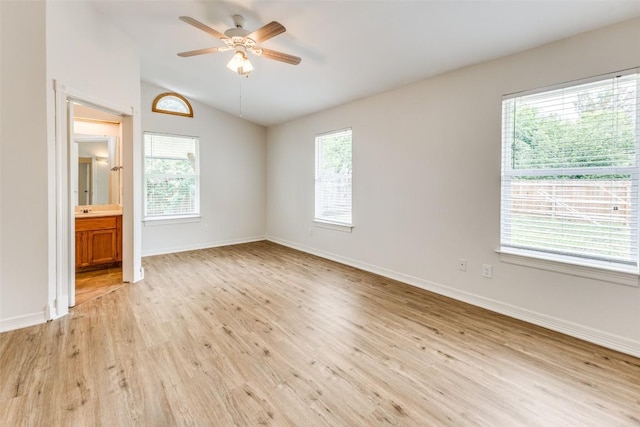 unfurnished bedroom with lofted ceiling, light hardwood / wood-style flooring, ceiling fan, and ensuite bathroom