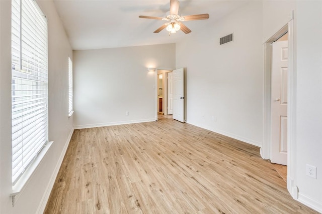 empty room with vaulted ceiling, ceiling fan, and light hardwood / wood-style floors