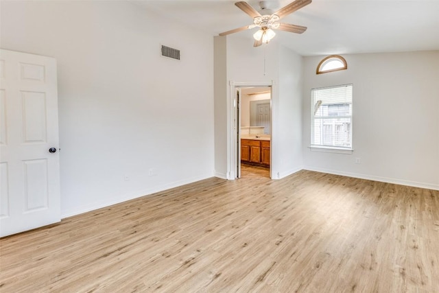 spare room featuring ceiling fan, lofted ceiling, and light wood-type flooring