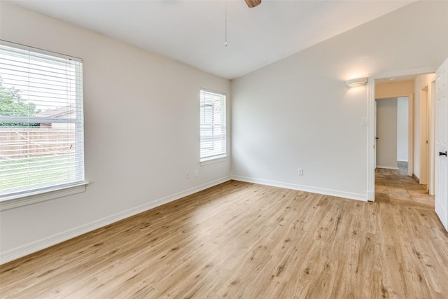 spare room featuring vaulted ceiling, light hardwood / wood-style floors, and ceiling fan