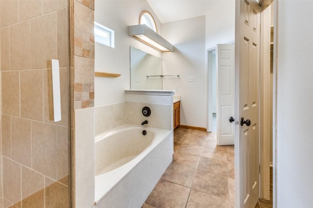 bathroom with vanity, tile patterned floors, and a tub to relax in