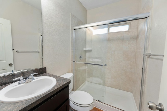 bathroom with an enclosed shower, vanity, and toilet