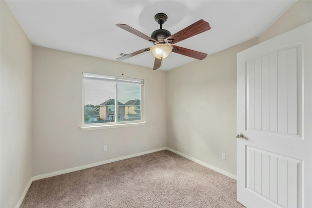 carpeted spare room featuring ceiling fan