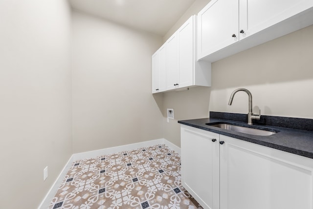 laundry room featuring cabinets, light tile patterned flooring, sink, and washer hookup