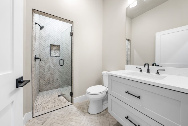 bathroom with vanity, toilet, and a shower with shower door