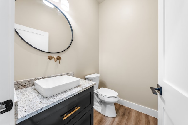 bathroom with hardwood / wood-style flooring, vanity, and toilet