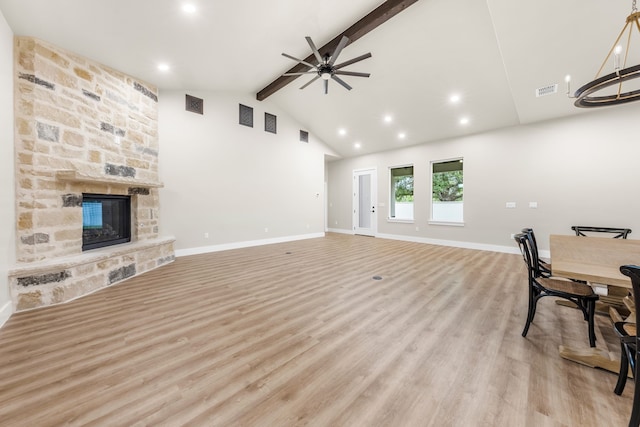 living room featuring lofted ceiling with beams, ceiling fan, a fireplace, and light hardwood / wood-style flooring