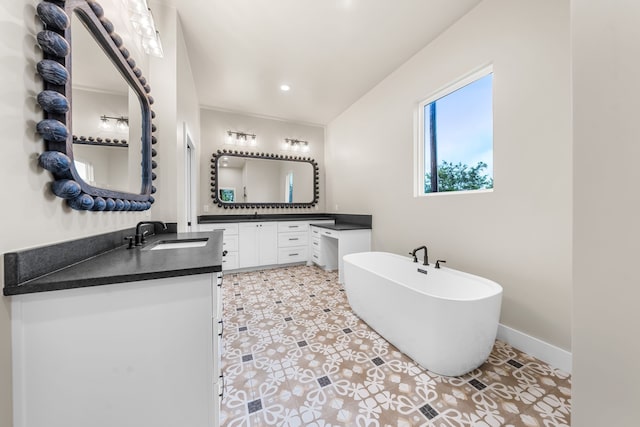 bathroom with vanity, tile patterned floors, and a tub to relax in